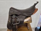une selle de cheval posée sur un support en bois à côté d'un porte-revues