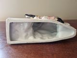 a white purse with a cell phone inside of it