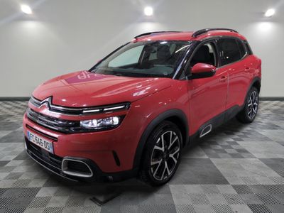 une citrole rouge est garee dans une piece avec un sol en damier