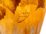 a close up of a vase with leaves on it