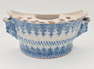 un vase bleu et blanc muni d'une anse, sur un fond blanc