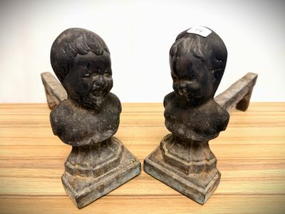 two statues of a boy and a girl on a wooden table