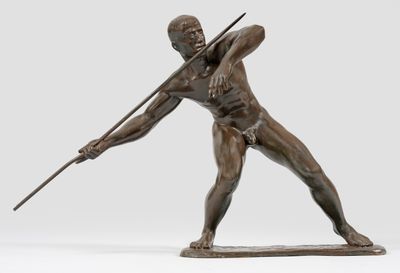 statue en bronze représentant un homme tenant une lance et un bâton