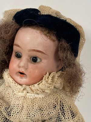 a close up of a doll wearing a hat and scarf