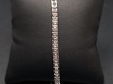 un bracelet « tennis » en diamants posé sur un coussin
