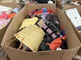 a cardboard box filled with lots of clothes and bags