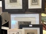 a lot of framed pictures on a table in a room