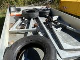 a truck with a trailer bed with a bunch of tires on it