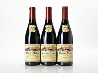 trois bouteilles de vin rouge posées sur une table blanche
