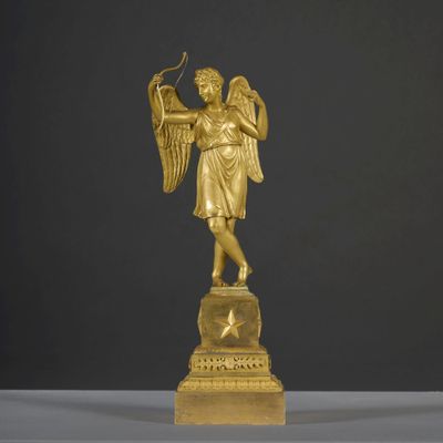 gold statue of an angel holding a bow and a bow in his hand
