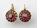 une photo d'une paire de boucles d'oreilles ornées d'une pierre rose