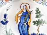 a plate with a painting of a woman holding a plant