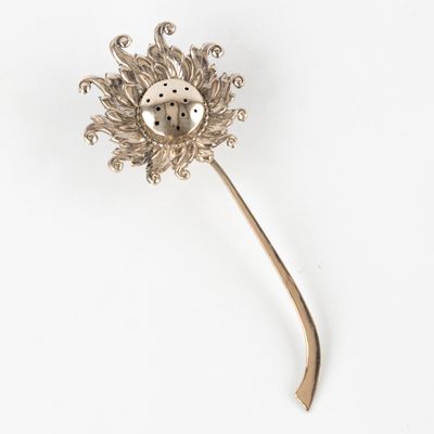 une broche en forme de fleur en argent ornée d'une coccinelle