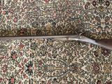 le fusil est posé sur le tapis, par terre