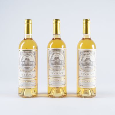 trois bouteilles de vin blanc posées l'une à côté de l'autre sur une surface blanche