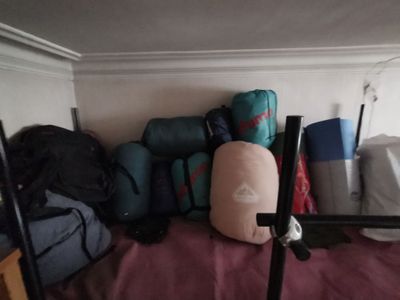 une pile de bagages posée sur un lit dans un coin de la pièce
