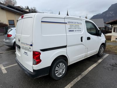 a white van parked in a parking lot with mountains in the background