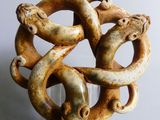 a sculpture of two snakes wrapped around a piece of wood