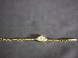 an image of a gold wrist watch with a chain around it