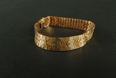 bracelet made of gold - plated metal on a black surface