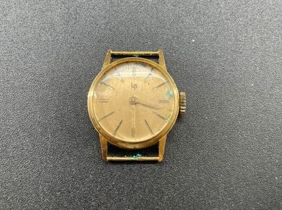 gros plan d'une montre en or sur une surface noire
