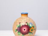 un petit vase sur lequel est peinte une fleur