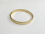 gros plan d'une bague en or sur une surface blanche