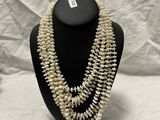 a close up of a necklace with pearls on a mannequin