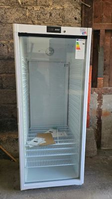 an empty refrigerator sitting in the middle of a room