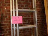 a ladder that has a sign on it in front of a brick wall