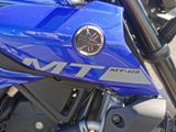 a close up of a blue motorcycle parked on the side of the road