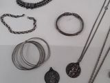 many different types of necklaces and bracelets on the table