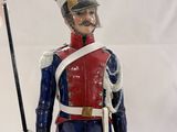 statue of a toy soldier holding a flag and a dog
