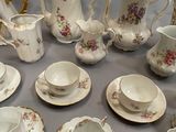 an assortment of porcelain tea and coffee cups and saucers