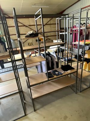 a rack of clothes in a room with a lot of shelves