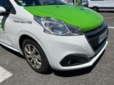 a green and white car parked in a parking lot
