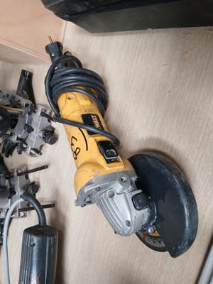 une image d'une ponceuse à fil posée sur un plancher en bois à côté d'autres outils