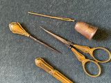 a pair of scissors and a needle rest on a table