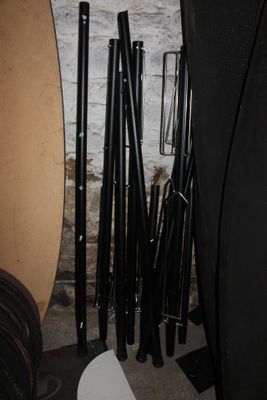 many different types of surfboards and paddles in the room