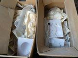 Deux boîtes de biberons et une bouteille d'eau sont posées par terre.