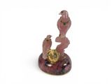 pink bird figurine with clock on marble base on white background