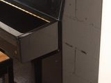 a black piano sitting next to a chair in a room
