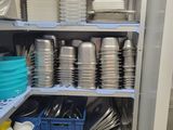 many plates and pans on the shelves in the kitchen