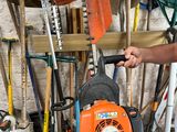 a man that is working on a chainsaw in a garage