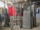 a pile of metal items in a warehouse with a ladder