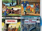 three books of comics are sitting on a white surface