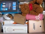 a brown teddy bear sitting in a box with other items