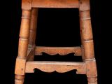 an old wooden stool with a wooden seat on a black background