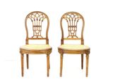 two wooden chairs with wicker seats and a cane back