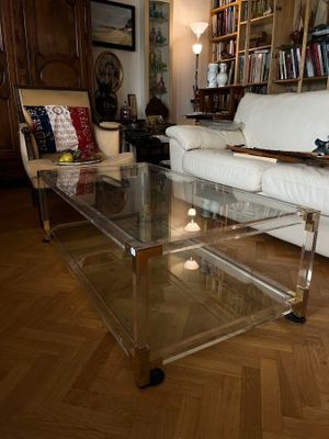 un salon avec un canapé blanc et une table basse en verre